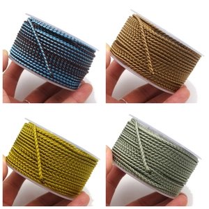 Detail view of 2.8mm braided dragon cords in various colors on white plastic spools