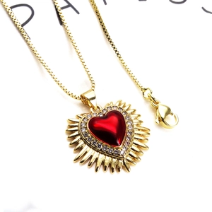 Collier rayon de soleil doré avec pendentif cœur rouge et oxydes de zirconium en vue principale