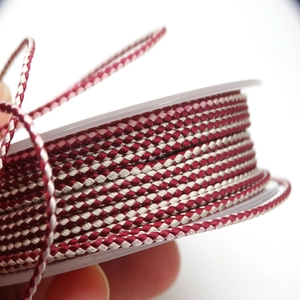Close-up of 1.5mm red and white two-tone braided cord with detailed spiral texture