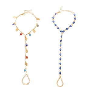 Vue détaillée de deux bracelets de main dorés avec charmes œil et main de Fatma.