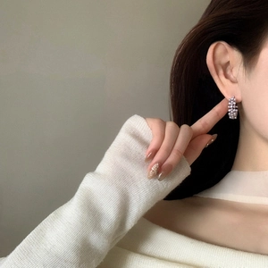 Élégantes créoles en perles vintage portées par un mannequin aux détails fins.