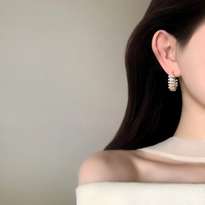 Vue détaillée de créoles élégantes ornées de perles de style vintage portées par un mannequin