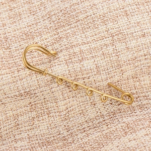 Close-up of gold-plated 4-loop safety pin for DIY jewelry accessories and waist adjustment.