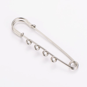 Detailed macro view of a silver-toned four-hole safety pin brooch for DIY jewelry crafting