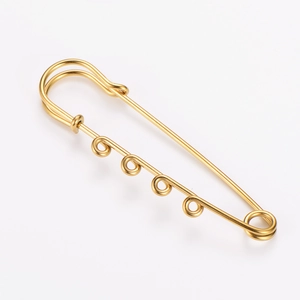 Detailed macro view of an 18k gold plated 4-hole safety pin for creative DIY jewelry.