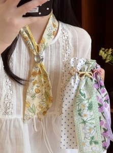 Detail of colorful floral and polka dot silk neck scarves with decorative buckles.