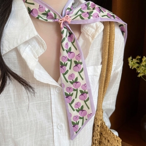 Close-up of elegant purple tulip floral print silk scarf featuring a pink bow clip
