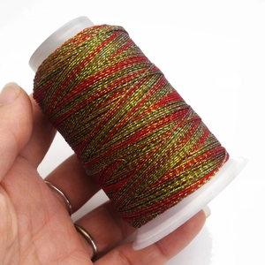 Macro view of multi-color gradient waxed cord spool held in hand for DIY jewelry making