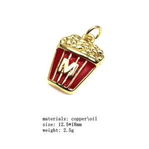 Détail d'un pendentif popcorn avec rayures émaillées rouges et blanches et lettre M