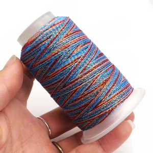 Macro detail of multi-colored wax thread roll held by hand for DIY jewelry crafting