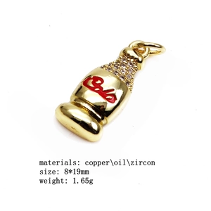 Vue détaillée d'un pendentif bouteille dorée de 1,65g avec émail rouge et zircons