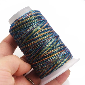 Close-up of rainbow gradient 6-ply waxed cord on spool for DIY jewelry weaving