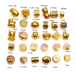 Detailed view of assorted gold-plated charms and beads featuring animal and floral motifs