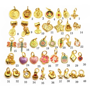 Collection of 40 gold enamel jewelry charms featuring religious and lucky motifs