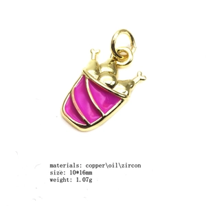Gros plan d'un pendentif frites de 10*16mm en cuivre rose avec zircons et émail