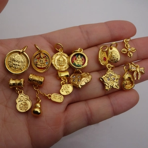 Collection of gold enamel charms featuring Buddhist deities and traditional symbols