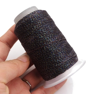 Dettaglio del cordoncino in cera intrecciata con fili metallici colorati su rocchetto