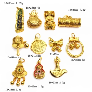 Detail showing assorted gold-plated charms with enamel accents and traditional patterns