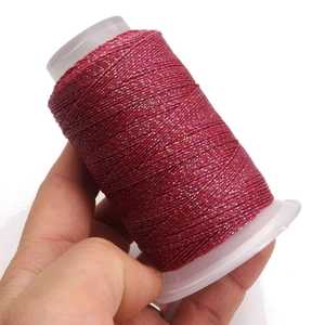 Dettaglio macro del rotolo di cordoncino cerato metallico magenta per gioielli e DIY