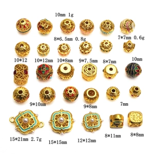Detail view of gold-plated hollow spacer beads and enamel charms for DIY jewelry making