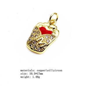 Détail d'un pendentif frites plaqué or avec coeur rouge et logo M orné de zircons cubiques