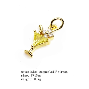 Détail macro d'un pendentif calice plaqué or avec zircon jaune et diamants blancs