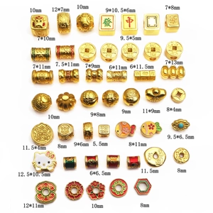 Macro detail of various gold-plated lucky charms featuring mahjong and coin patterns