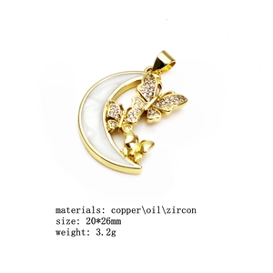Macro view of gold-plated moon and butterfly pendant with zircon inlay and enamel detail