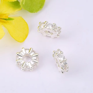 Macro view of three silver spacer beads with zircon stones for DIY jewelry making