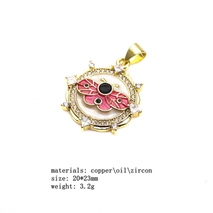 Detail view of round gold pendant with butterfly enamel design and cubic zirconia