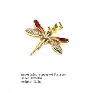 Detailed view of gold copper dragonfly pendant with red enamel and white zircon 25*23mm