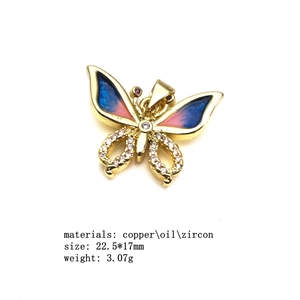 Macro detail of gold-plated butterfly pendant with blue enamel and cubic zirconia stones