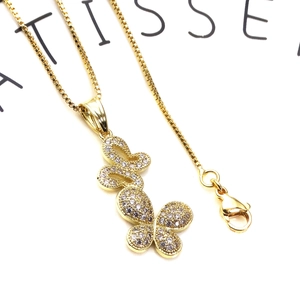 Detail of gold butterfly pendant with cubic zirconia inlay on a delicate box chain
