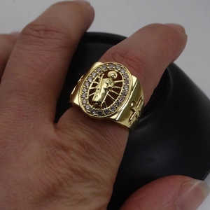 Macro detail of gold religious saint ring with zircon halo and side cross engravings
