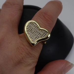 Close-up of heart-shaped gold ring with micro-pave white zircon stones on finger