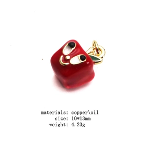 Macro detail of red apple charm in copper and oil drip with cartoon face 10x13mm size