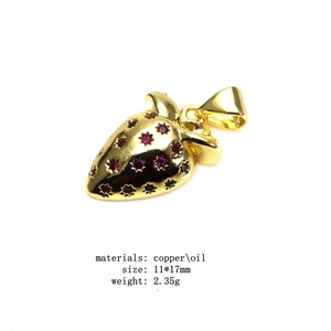 Detail of red strawberry charm with gold plating and cubic zirconia for jewelry making