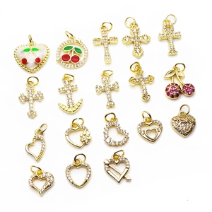 Auswahl an vergoldeten Anhängern wie Kirsche, Kreuz, Herz und Anker für Schmuck