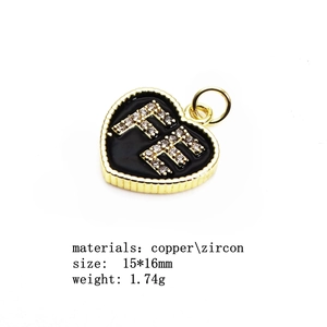 Macro shot of 15x16mm gold heart pendant with FE zircon letters and black enamel base