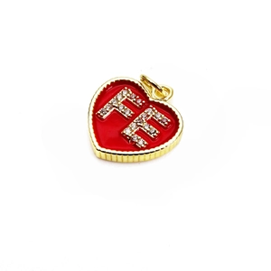 Macro view of gold heart pendant with red enamel, FE letters and sparkling zircons