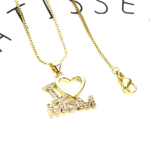 Macro shot of gold plated I Love MOM heart pendant with cubic zirconia and box chain