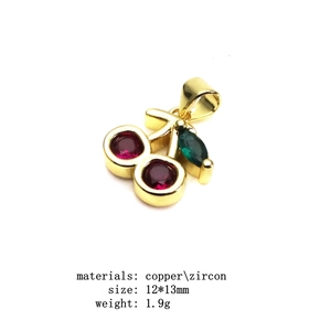 Macro detail of cherry pendant with red cubic zirconia and green marquise stone