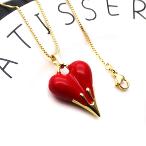 Macro shot of red heart enamel pendant with gold-plated box chain and lobster clasp