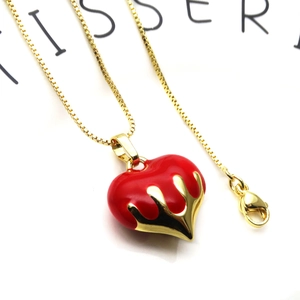 Detail view of red enamel heart pendant with gold lava flow on a fine box chain