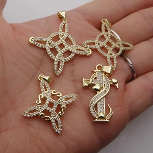 Gold plated copper Celtic knot pendants with white cubic zirconia crystals set on hand