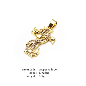 Macro view of gold dollar sign cross pendant with micro-inlaid zircon and heart detail