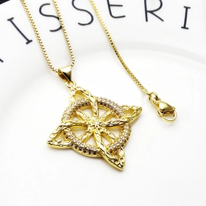 Close-up of gold Celtic knot pendant necklace featuring micro-set cubic zirconia on box chain
