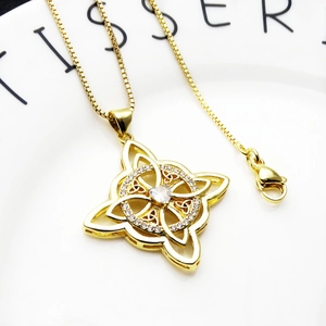Detail of Celtic knot necklace with heart-shaped zircon on a white ceramic tray