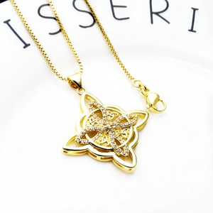 Macro shot of gold-plated Celtic knot necklace pendant micro-set with white zircons