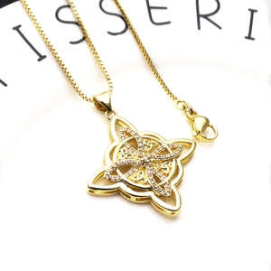 Macro detail of gold Celtic knot pendant with cubic zirconia on a box chain